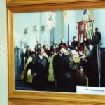 Old communist Mikhail Kalashnikov encounters bishop at a religious ceremony to give thanks to God for 190 years of guns in Izhevsk.